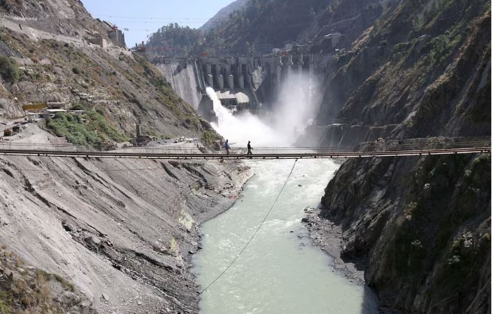 Labourers walk on a bridge near the 450-megawatt hydropower project located at Baglihar Dam on the Chenab river which flows from Indian Kashmir into Pakistan, at Chanderkote, about 145 km (90 miles) north of Jammu October 10, 2008. REUTERS/Amit Gupta/File Photo