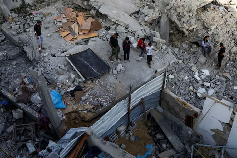 Palestinians inspect the site of an Israeli strike on a house, in Khan Younis in the southern Gaza Strip, May 3, 2025.