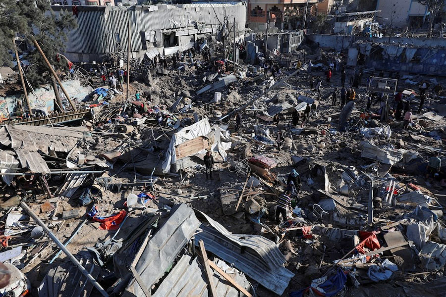 Palestinians inspect the site of an Israeli strike on an UNRWA school sheltering displaced people, in the Bureij camp in the central Gaza Strip, May 7, 2025.