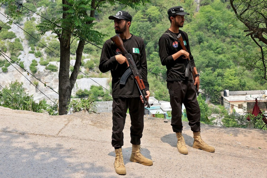Police officers stand guard on a road leading to Bilal Mosque after it was hit by an Indian strike in Muzaffarabad, the capital of Pakistan-administered Kashmir, May 7, 2025.