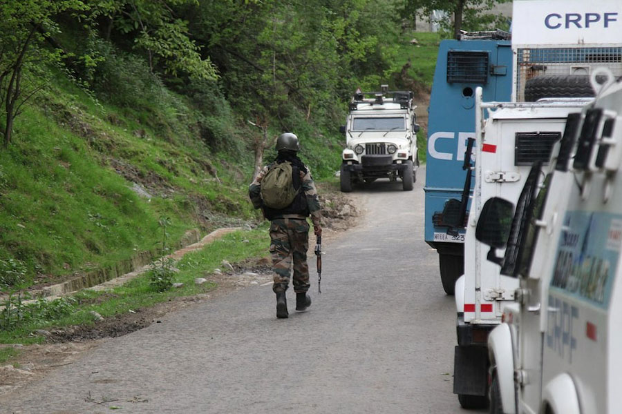 An Indian security force trooper moves past parked vehicles during a cordon and search operation, following an attack on tourists near Pahalgam, in Gudder village of south Kashmir's Kulgam district April 26, 2025.