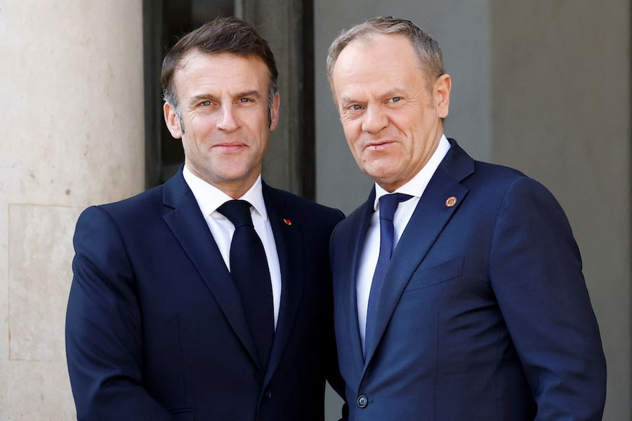 French President Emmanuel Macron welcomes Polish Prime Minister Donald Tusk as he arrives for a meeting with European leaders and Ukraine's President Volodymyr Zelenskiy on peace and security for Ukraine, at the Elysee Palace in Paris, France, March 27, 2025.