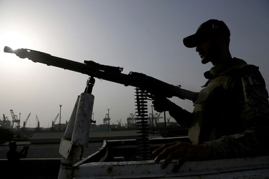 A paramilitary trooper mans a gun atop a vehicle as he keeps guard during a media tour of the Karachi Port, Pakistan, May 9, 2025.
