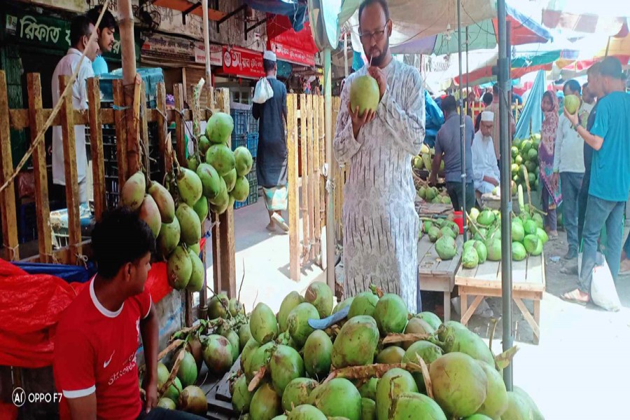 To quench his overwhelming thirst during the ongoing hot spell, a man is taking green coconut water at a shop in Rangpur city on Sunday- FE Photo