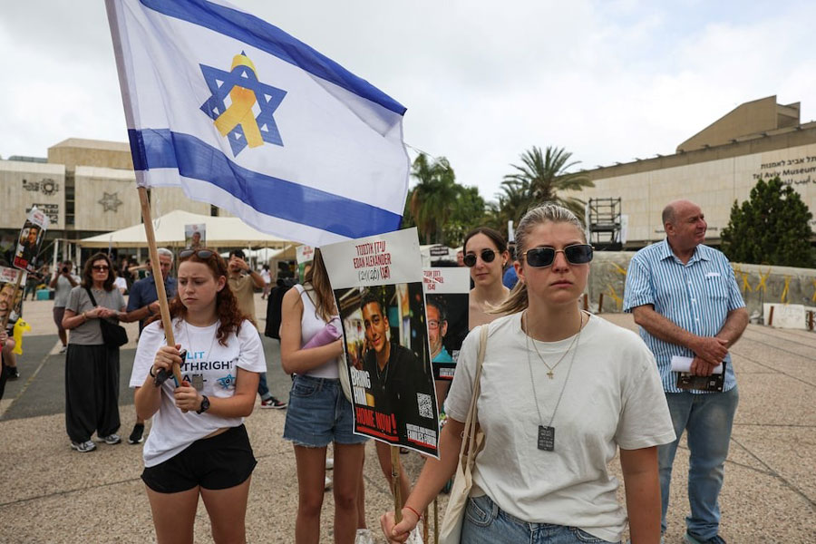 People gather, on the day Israeli-American hostage Edan Alexander, who was kidnapped during the deadly October 7 attack, is expected to be released from captivity by Hamas in Gaza, in Tel Aviv, Israel May 12, 2025.