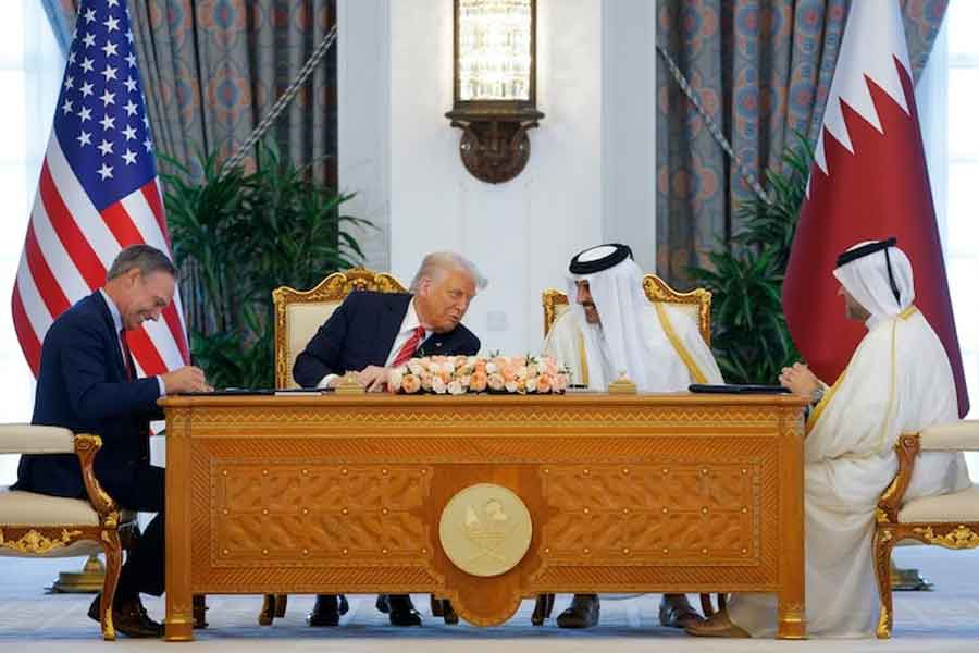 US President Donald Trump, Qatar's Emir Tamim bin Hamad Al Thani and Boeing CEO Kelly Ortberg attend a signing ceremony in Doha, Qatar, May 14, 2025.