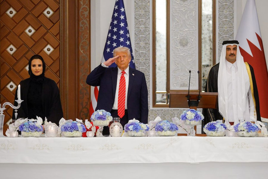 US President Donald Trump salutes next to Qatar's Emir Tamim bin Hamad Al Thani as the US anthem is played on the day of a state dinner, at Lusail Palace in Lusail, Qatar, May 14, 2025.