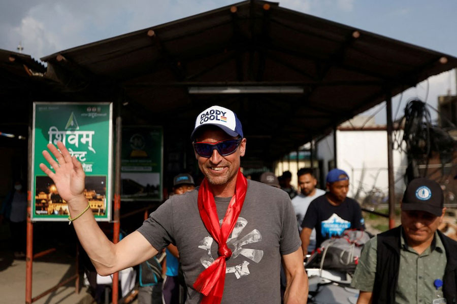 British climber Kenton Cool, 49, waves towards the media personnel, upon his arrival at the airport, as he returns after completing his 17th ascent of Mount Everest, which is the most by any foreign climber, in Kathmandu, Nepal May 19, 2023.