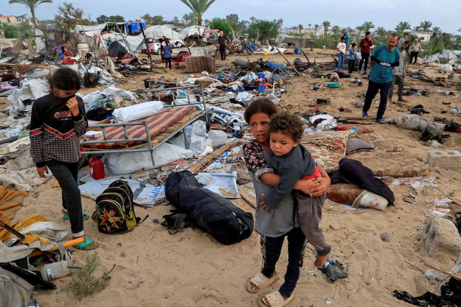 Palestinians inspect the damage at the site of an Israeli strike on a tent camp sheltering displaced people, in Khan Younis, southern Gaza Strip, May 18, 2025.