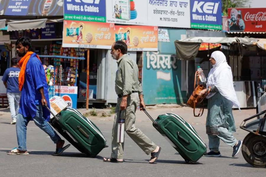 People carry baggage as they travel towards the Attari-Wagah crossing on the India-Pakistan border near Amritsar, following Tuesday’s attack on tourists near south Kashmir’s scenic Pahalgam, India, April 25, 2025.