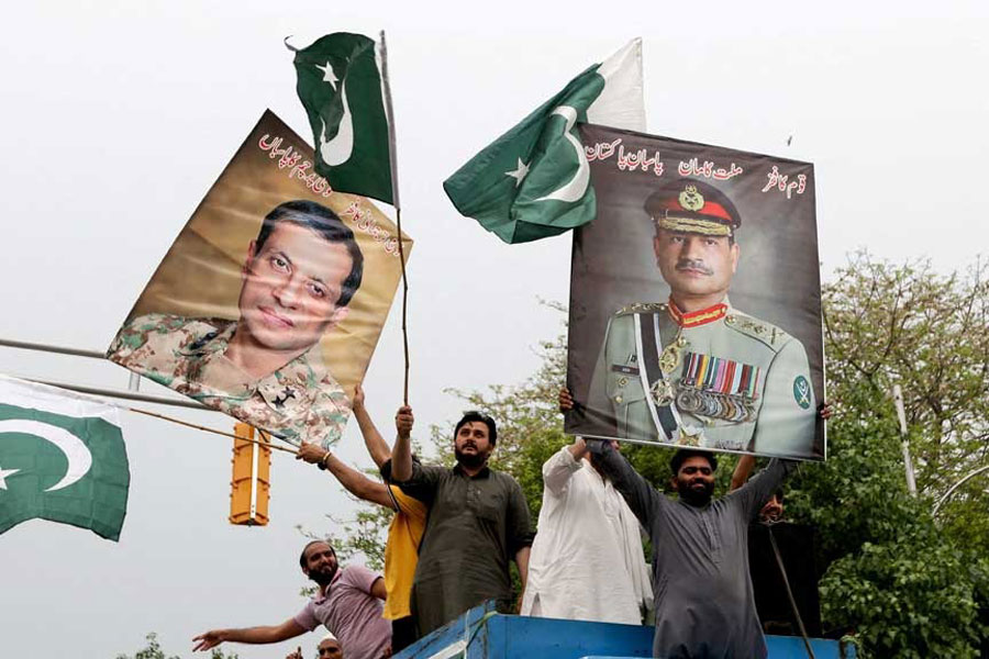 People carry posters showing the pictures of Chief of Army Staff of Pakistan Asim Munir, (R) along with Ahmed Sharif Chaudhry, Director General of Inter-Service Public Relations wing of Pakistan Armed Forces, as they take part in a rally in support of Pakistan Army, day after the ceasefire announcement between India and Pakistan, in Lahore, Pakistan, May 11, 2025.