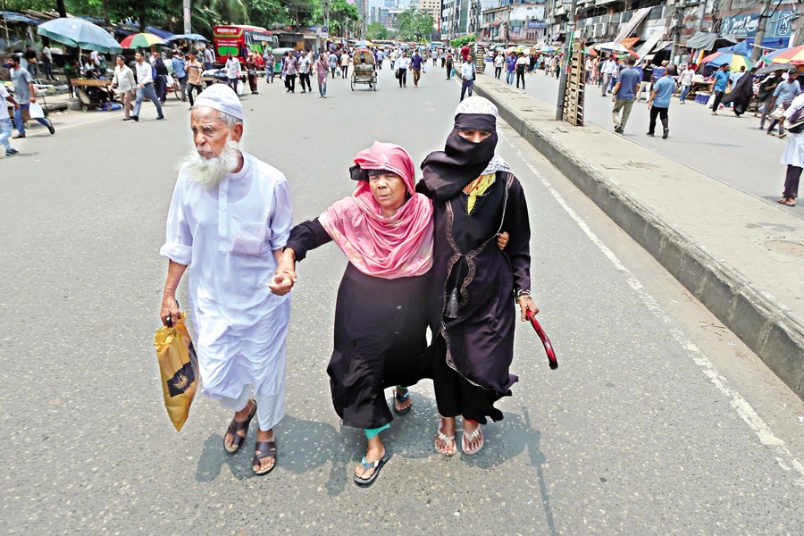 Three commuters at Gulistan in the capital trying to reach their destination on foot, as supporters of BNP leader Ishraque Hossain blocked the roads around the Nagar Bhaban and halted traffic on Tuesday to press for implementation of their demands