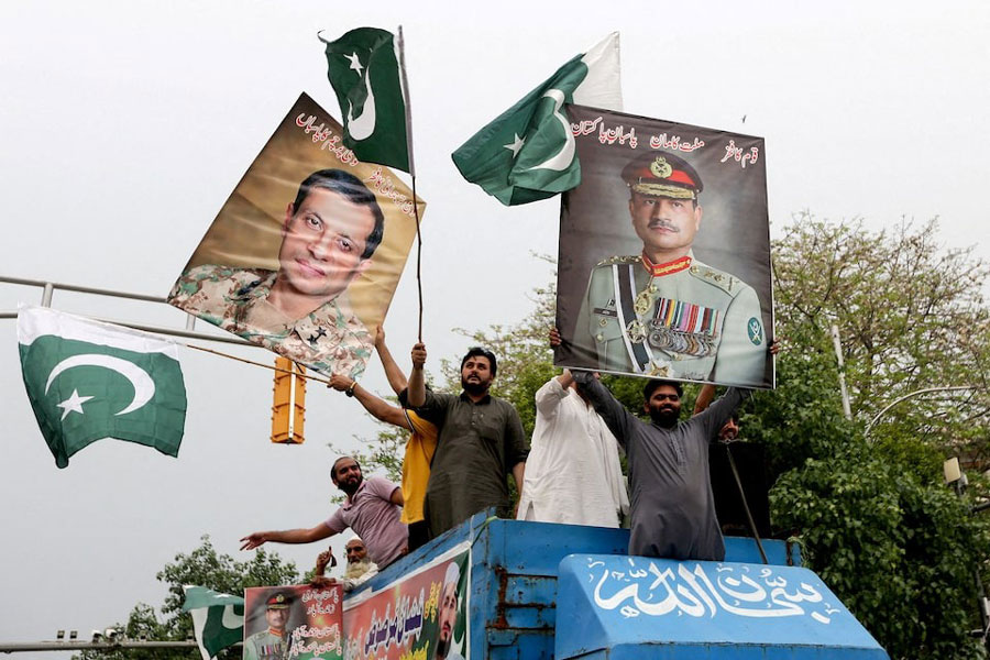 People carry posters showing the pictures of Chief of Army Staff of Pakistan Asim Munir, (R) along with Ahmed Sharif Chaudhry, Director General of Inter-Service Public Relations wing of Pakistan Armed Forces, as they take part in a rally in support of Pakistan Army, a day after the ceasefire announcement between India and Pakistan, in Lahore, Pakistan, May 11, 2025.