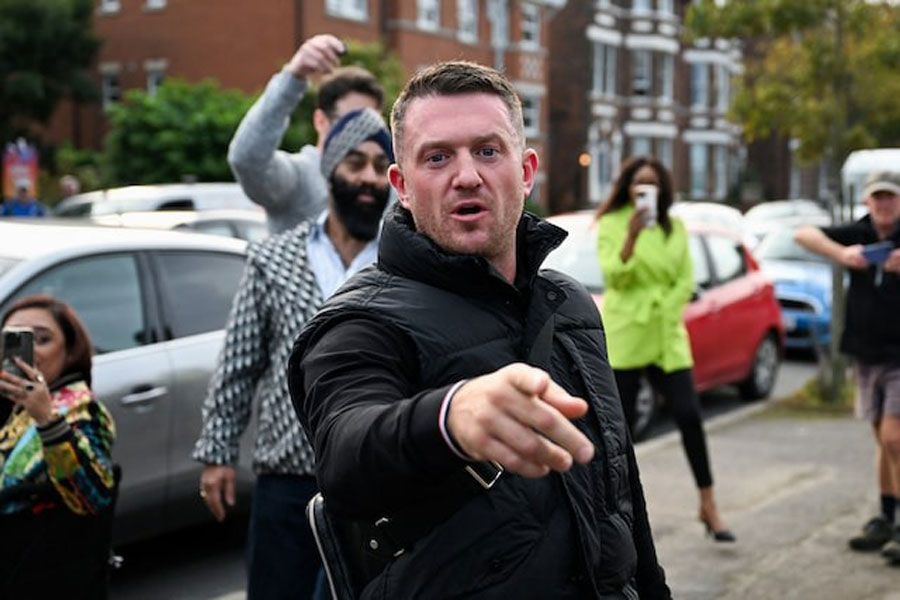Anti-immigration activist Stephen Yaxley-Lennon, known as Tommy Robinson, gestures before arriving at Folkestone Police Station in Folkestone, Britain, October 25, 2024.