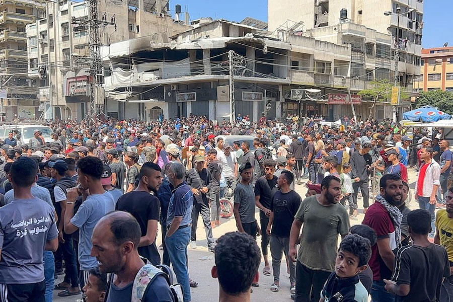 Palestinians wait to receive aid, in Gaza City, May 25, 2025.
