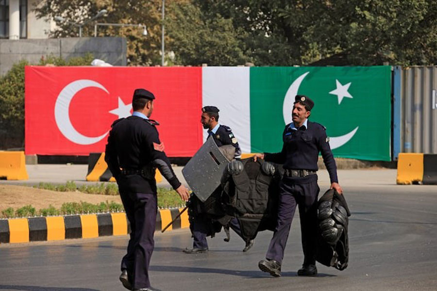 Policemen walk near the national flags of Pakistan and Turkey displayed along a road ahead of a visit of Turkish President Tayyip Erdogan in Islamabad, Pakistan, November 16, 2016.