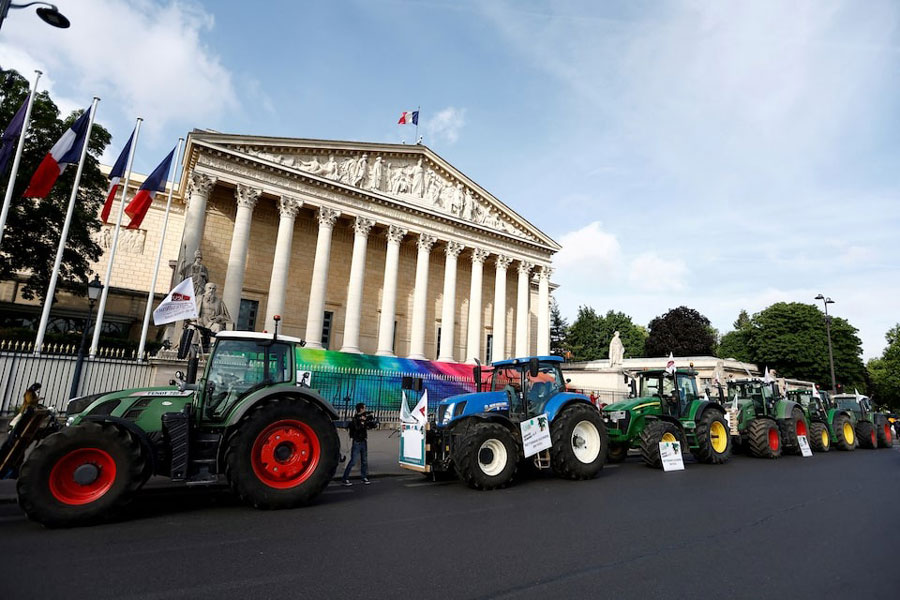 Tractors are parked in front of the French parliament, the Assemblee Nationale, as French farmers gather for a protest to call on lawmakers to adopt a bill that would loosen restrictions on pesticide and water use in farming, in Paris, France May 26, 2025.