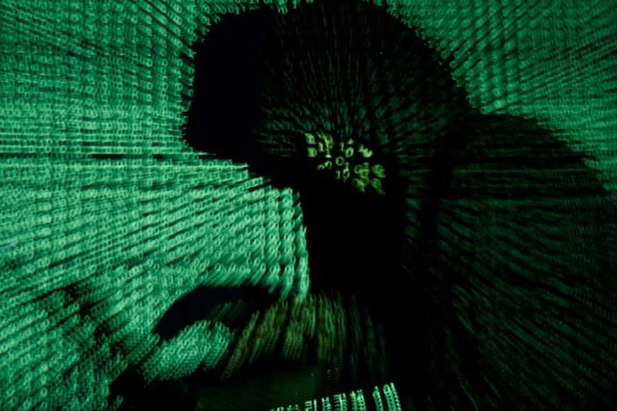 A man holds a laptop computer as cyber code is projected on him in this illustration picture taken on May 13, 2017.