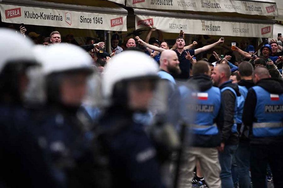 Conference League - Final - Real Betis & Chelsea fans gather in Wroclaw - Wroclaw, Poland - May 28, 2025 Police officers look on as Chelsea fans are seen outside a restaurant ahead of the match REUTERS/Dylan Martinez