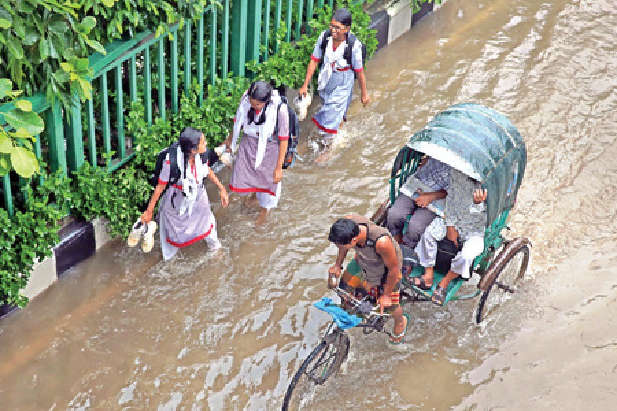 The area in fornt of the Motijheel Govt Boys High School in the city remains inundated on Wednesday after overnight downpour.- FE photo by KAZ sumon