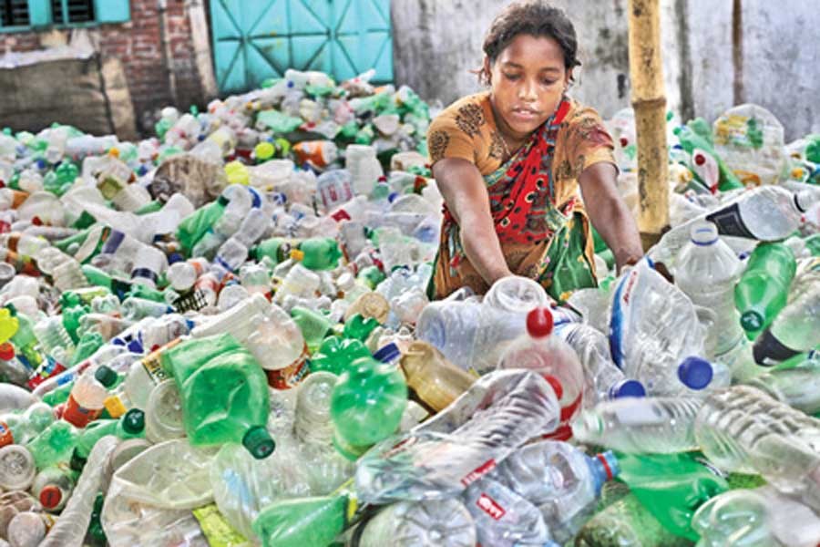 A woman picks bottles to be used in plastic recycling factories. The picture was taken from Kamrangirchar area. --FE Photo