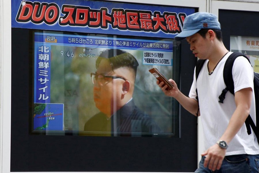 A man walks past a TV set showing North Korea's leader Kim Jong-Un in a news report about North Korea's missile launch over Japan on Tuesday.