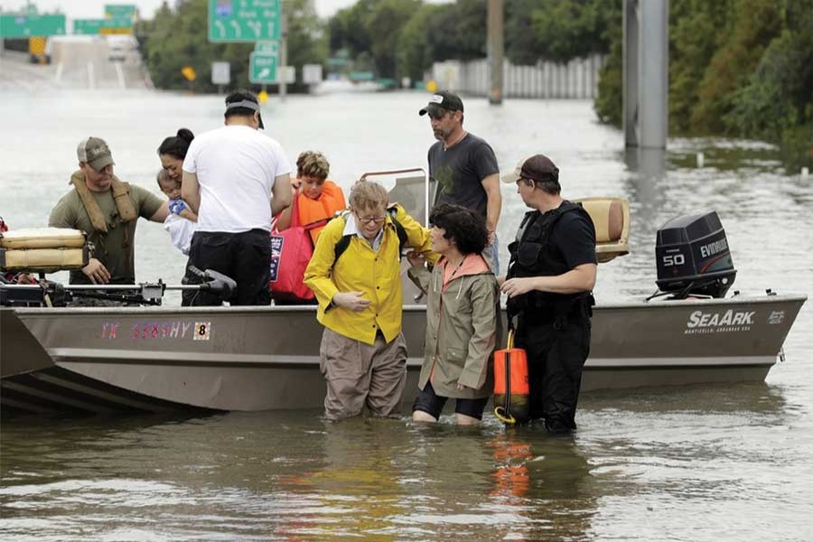 Rescuers with Houston residents evacuated from their flooded homes during Tropical Storm Harvey. — AP photo