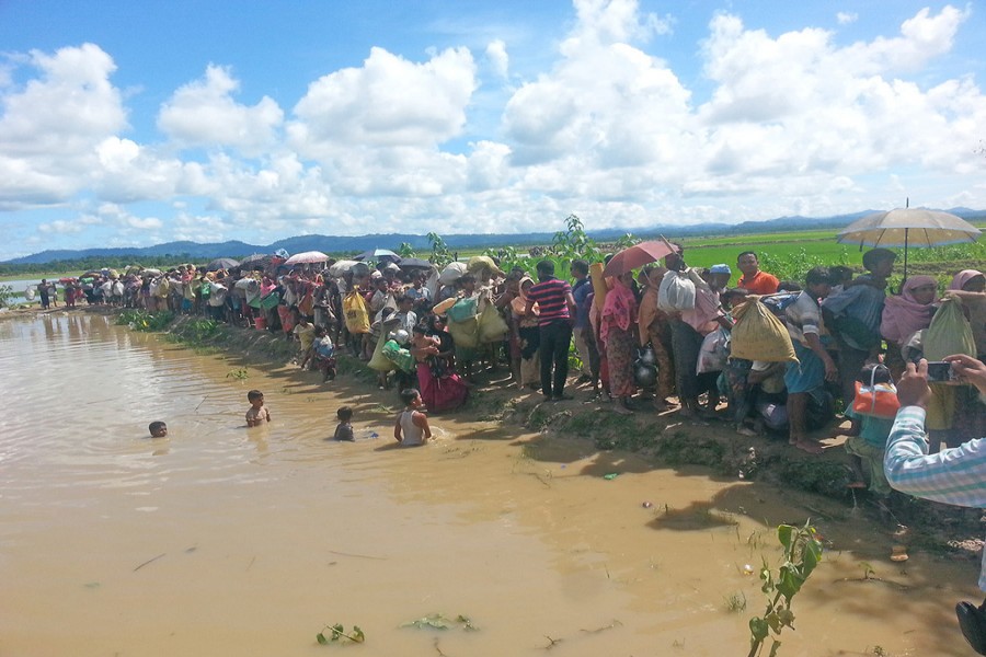 A group of Rohingyas walking towards a refugee camp after crossing the Bangladesh-Myanmar border through Ukhia in Cox’s Bazar on Sunday. — FE photo