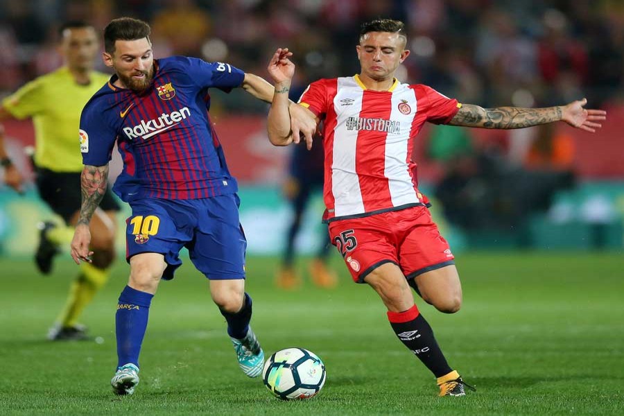 Barcelona's Lionel Messi in action with Girona's Pablo Maffeo during the Santander La Liga match between Girona and FC Barcelona at Estadi Montilivi stadium in Girona, Spain on Saturday. — Reuters