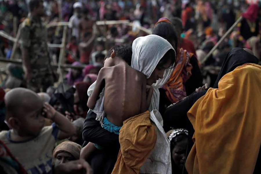 A woman carries her ill child in a refugee camp at Cox's Bazar, Bangladesh. Approximately 480,000 Rohingya Muslims have fled to Bangladesh since August following an Army crackdown in Myanmar's Rakhine State.- Reuters photo