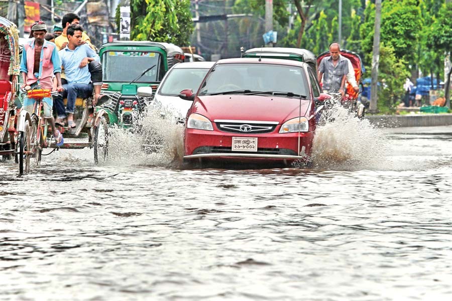 Vehicles ply the Fakirerpul area in the city where roads went under water after rain on Friday. — FE photo