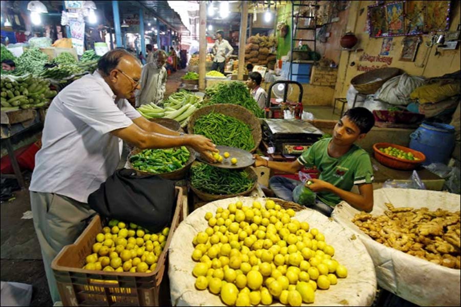 A man buys lemons at a market in Ahmedabad. - Reuters photo