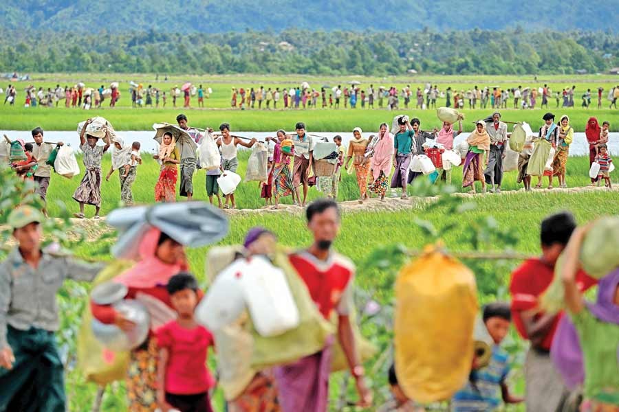 Rohingya refugees, who crossed the border from Myanmar two days before, walk to the refugee camps in Palang Khali, near Cox's Bazar, on Thursday as the Bangladesh Army allowed them in. — Reuters