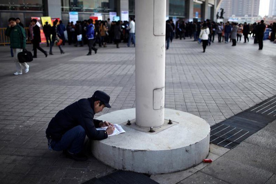 A job seeker fills in application forms during a job fair at Shanghai Stadium February 4, 2012. - Reuters file photo