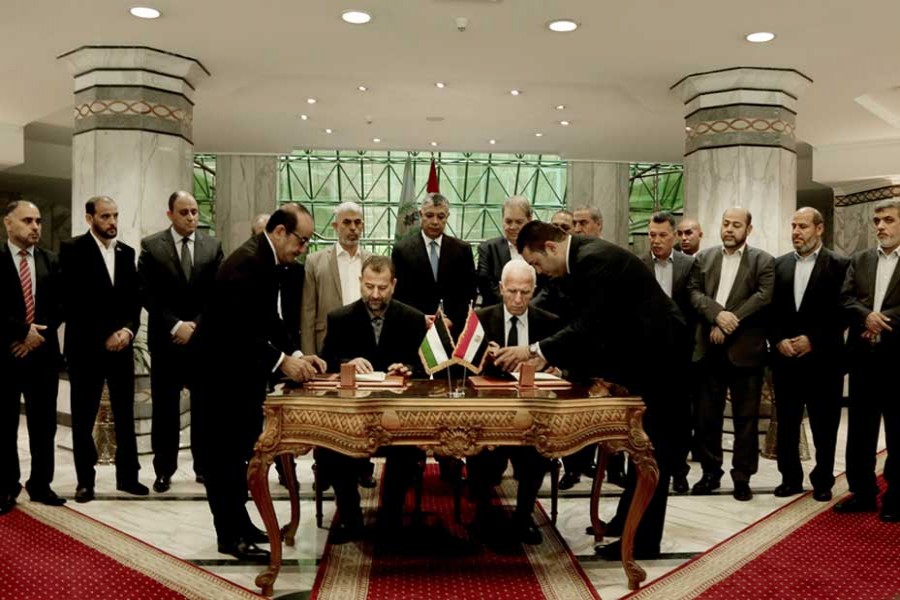 Senior Fatah official Azzam al-Ahmad, centre right, and Hamas' representative, Saleh al-Arouri, centre left, sign a reconciliation agreement during a press conference at the Egyptian intelligence complex in Cairo, Egypt on October 12, 2017. — Photo: AP
