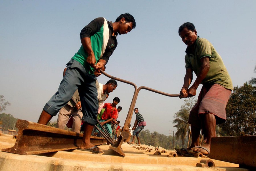Labourers work at the installation site of a new railway track in Agartala, India. — Reuters File Photo