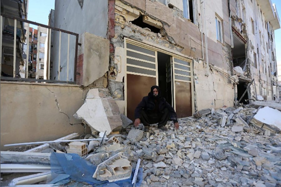 A man sits outside a damaged belonging following an earthquake in Sarpol-e-Zahab county in Kermanshah, Iran on Monday. - Reuters photo