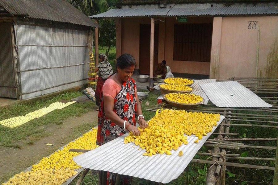 NATORE: A housewife dries lentil dumpling in Boraigram upazila on Saturday. — FE Photo