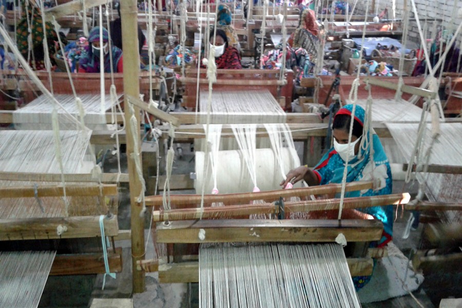 RANGPUR: Johra Begum makes doormat at a factory in Tajhat area of Rangpur city on Monday. — FE Photo