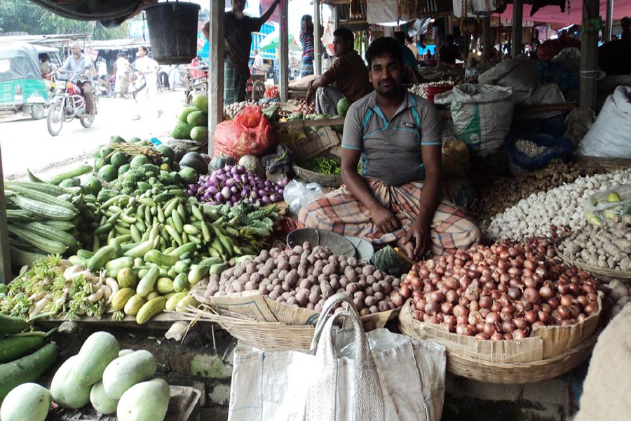 A vendor waits for customers at his shop in a kitchen market in Bogra Sadar on Wednesday. — FE Photo