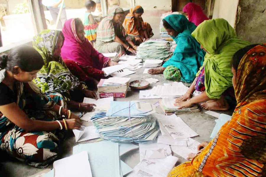 BOGRA: A group of female workers busy making paper packets in Muroil village under Kahaloo upazila. — FE photo