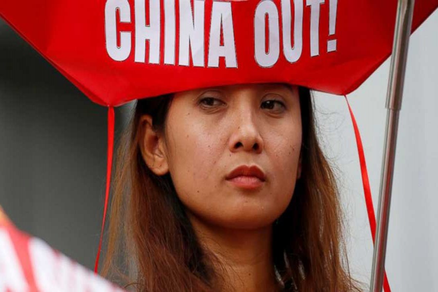 A protester holds a flag during a rally at the Chinese Consulate to protest China's alleged continued militarisation of the disputed islands in the South China Sea known as Spratlys Saturday, Feb. 10, 2018 in the financial district of Makati city east of Manila, Philippines. - AP