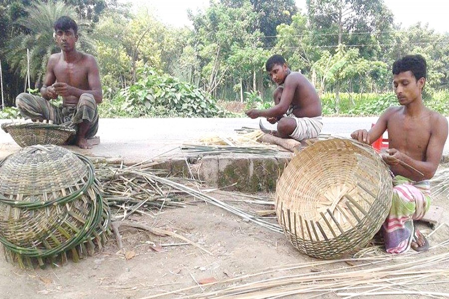 Artisans busy making bamboo items in Charmohor upazila of Pabna on Tuesday. — FE Photo