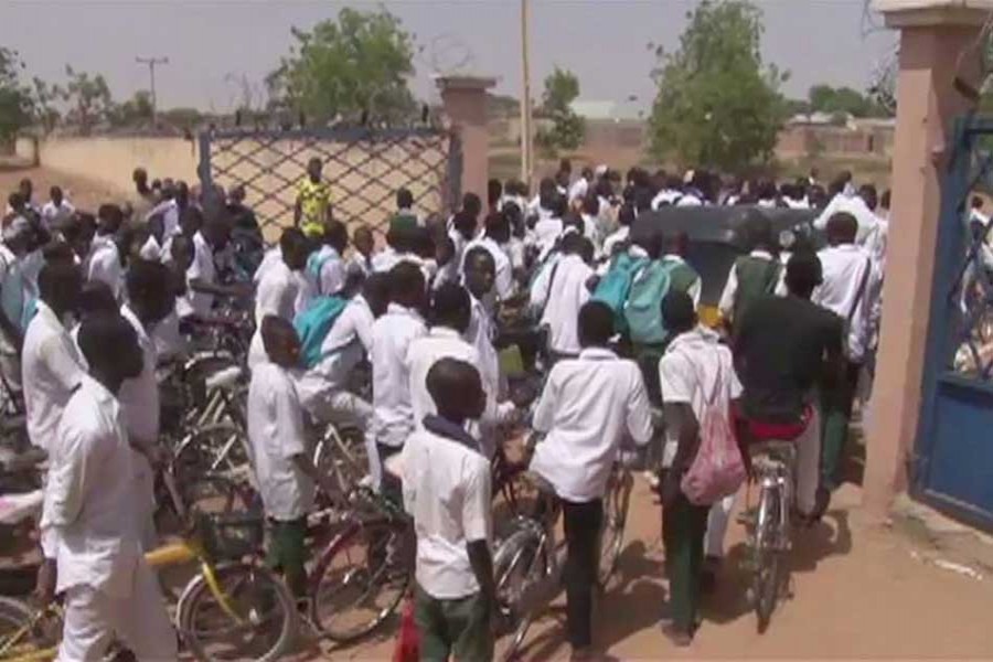 In this image from TV, students steam through the school security gates as they leave school, in Damaturu, Nigeria, Monday Feb. 26, 2018. - AP