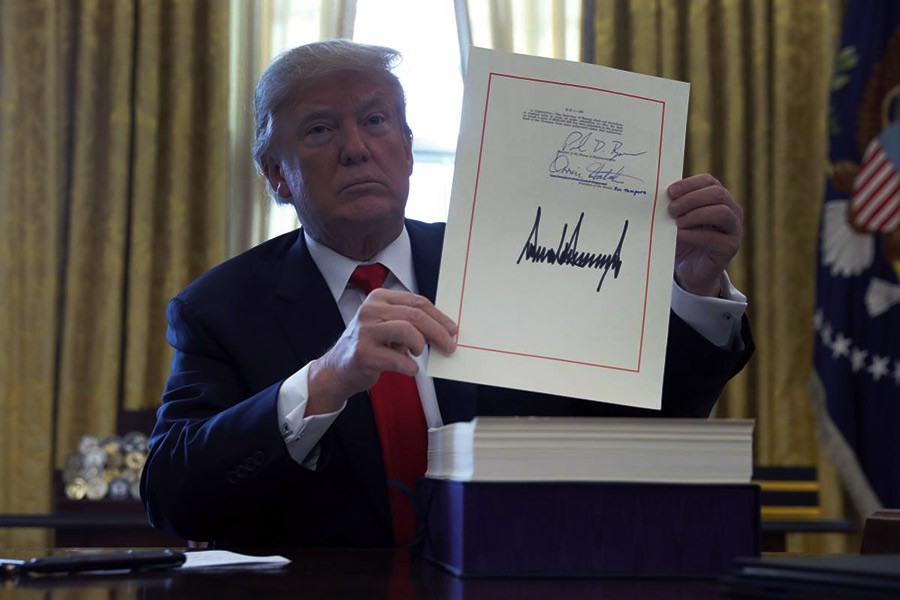 US President Donald Trump displays his signature after signing the $1.5 trillion tax overhaul plan in the Oval Office of the White House in Washington on December 22, 2017. —Photo: Reuters