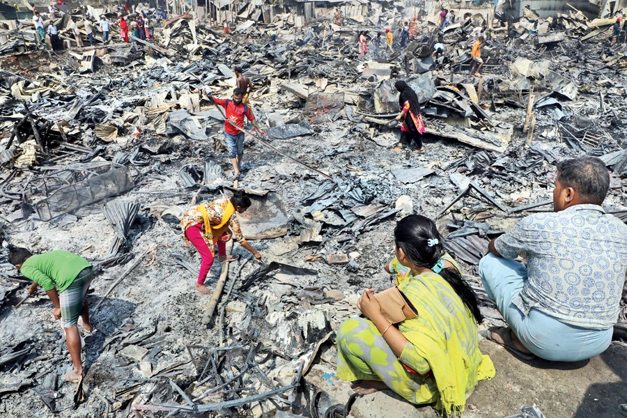Residents of a slum at Mirpur-12 try to trace their belongings amid debris after a terrible fire burnt to ashes more than 4,000 shanties there on Monday. — FE Photo by Shafiqul Alam