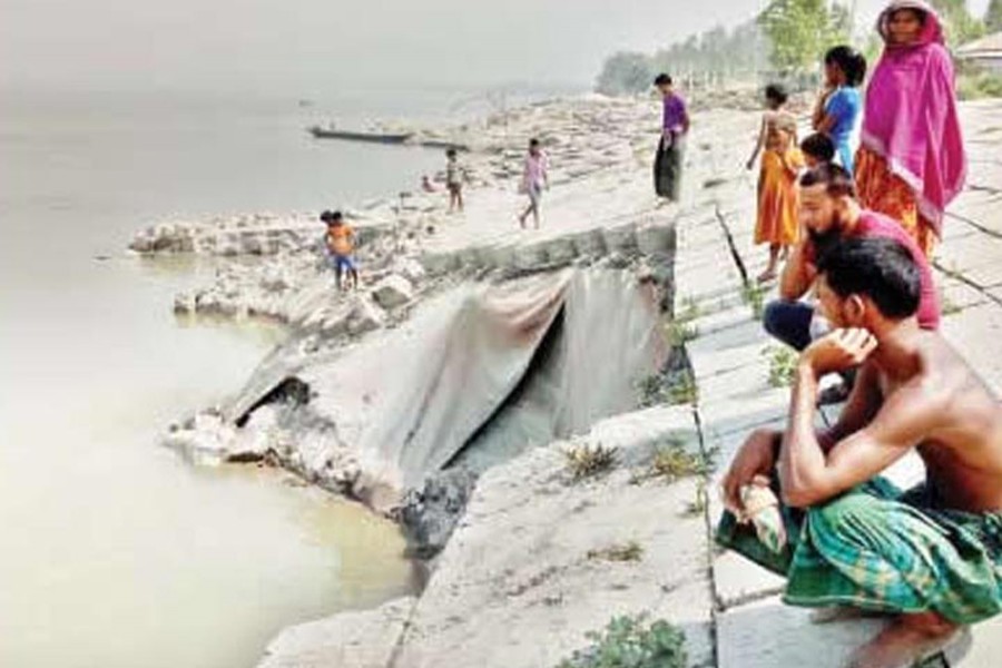 Anxious inhabitants of Khas Kaulia area under Chouhali upazila of Sirajganj sitting beside the collapsed embankment. The snap was clicked on Monday — FE photo