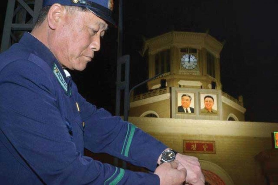 An unidentified uniformed man adjusts his wristwatch in front of a clock of the Pyongyang Station in Pyongyang, North Korea, early Saturday, May 5, 2018. North Korea readjusted its time zone to match South Korea's on Saturday and described the change as an early step toward making the longtime rivals "become one" following a landmark summit. The portraits seen in the background are the late leaders, Kim Il Sung, left, and Kim Jong Il. —Photo: AP