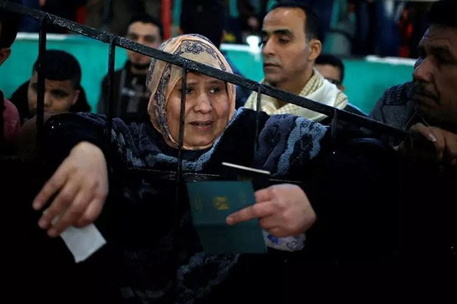 A woman waits for a travel permit to cross into Egypt through the Rafah border crossing after it was opened by Egyptian authorities for humanitarian cases, in the southern Gaza Strip on February 21 last - Reuters photo