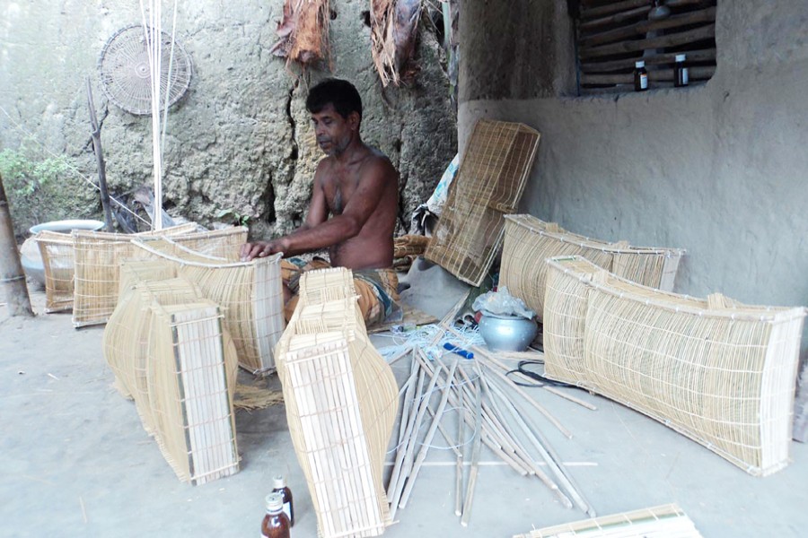 A craftsman making traditional bamboo-made fishing gear in Kahaloo upazila of Bogura on Sunday — FE Photo